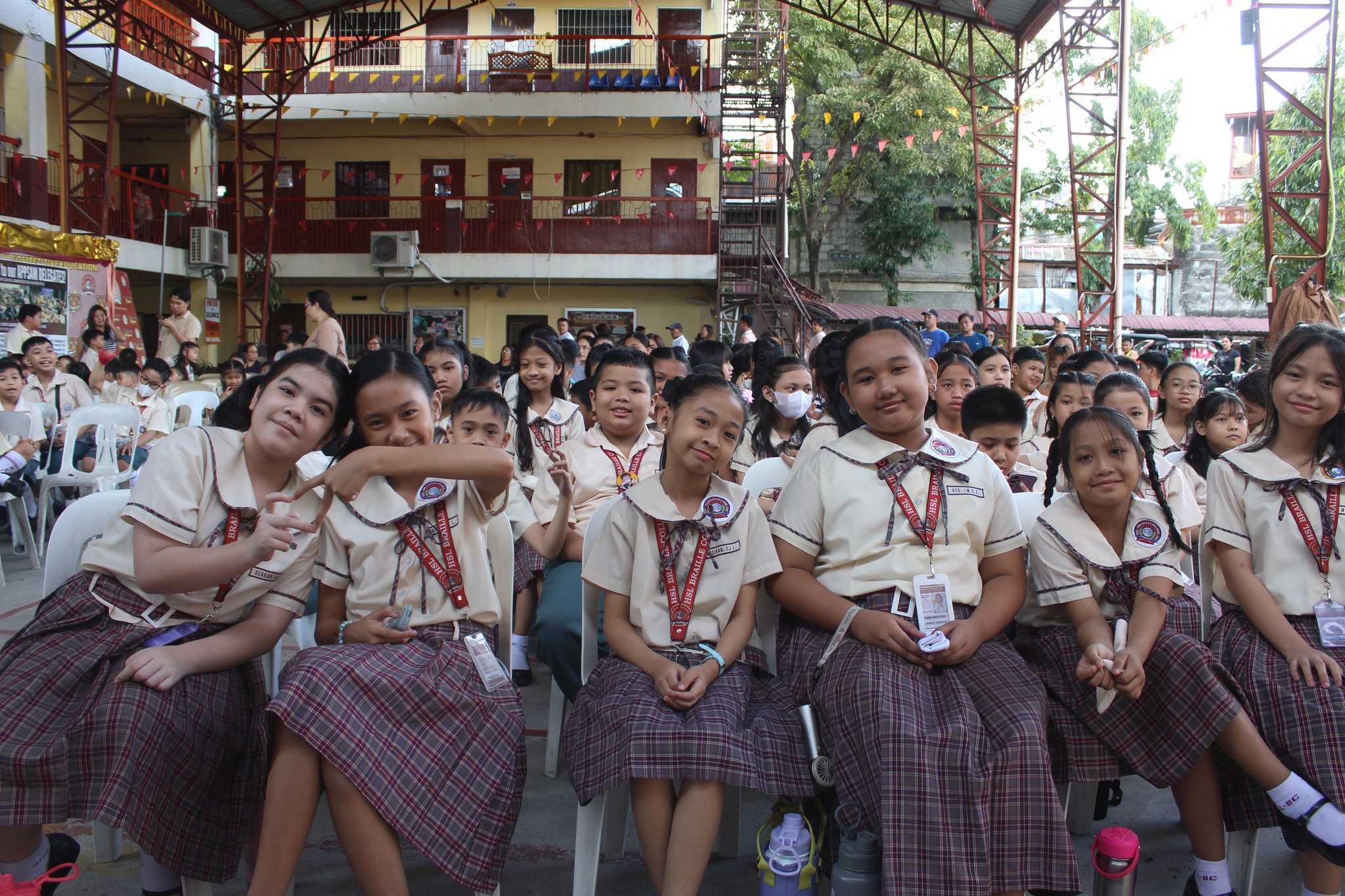Elementary Grade students sitting in a school courtyard